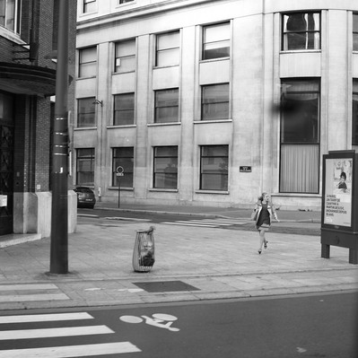 Black and white street photography of the french street photographer David Décamps representing a woman running to get her train in Paris.