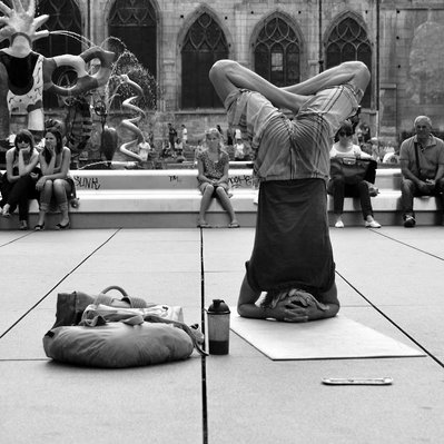 Black and white street photography of the french street photographer David Décamps representing a man upside down doing his yoga in Paris.