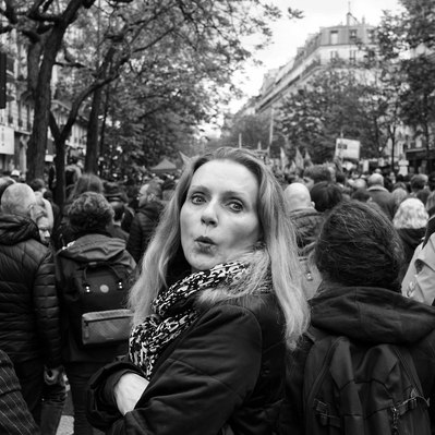 Black and white street photography of the french street photographer David Décamps representing a woman with a surprise face during a strike in Paris.