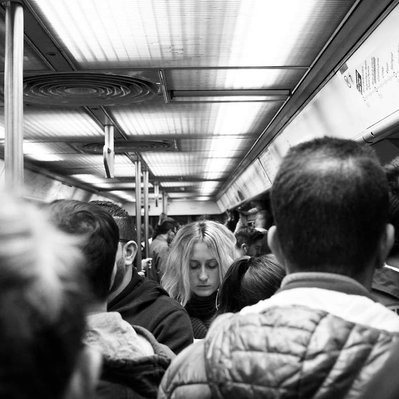 Black and white street photography of the french street photographer David Décamps representing a girl in the middle of a crowd in the subway in Paris.