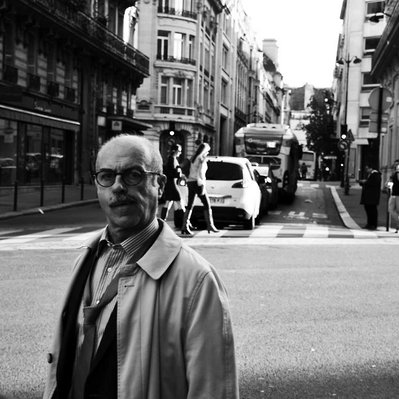 Black and white street photography of the french street photographer David Décamps representing a man with his tie off on the sidewalk in Paris.
