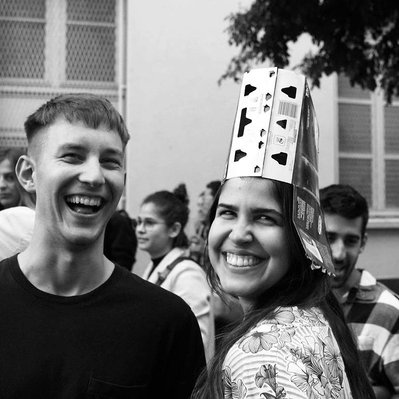 Black and white street photography of the french street photographer David Décamps representing two young people and a girl with a beer hat in Paris.