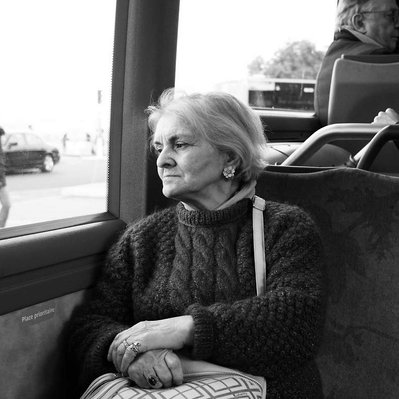 Black and white street photography of the french street photographer David Décamps representing a woman with melancholy in a bus in Paris.