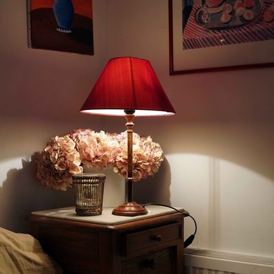 Street photography in colors of the french street photographer David Décamps representing the corner of a couch with a red light in an house in France.