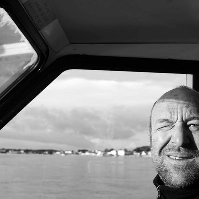 Black and white street photography of the french street photographer David Décamps representing a man blinking in a boat in France.