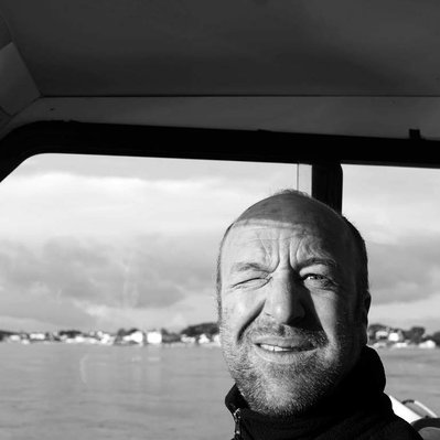 Black and white street photography of the french street photographer David Décamps representing a man blinking in a boat in France.