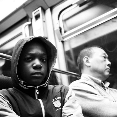 Black and white street photography of the french street photographer David Décamps representing a teenager with an intense look in Paris, France.