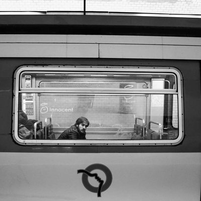 Black and white street photography of the french street photographer David Décamps representing a man with a sad look in the subway in Paris.