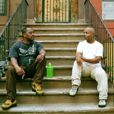 Street photography in colors of the french street photographer David Décamps representing two men having a conversation on a stair in New York City, USA.