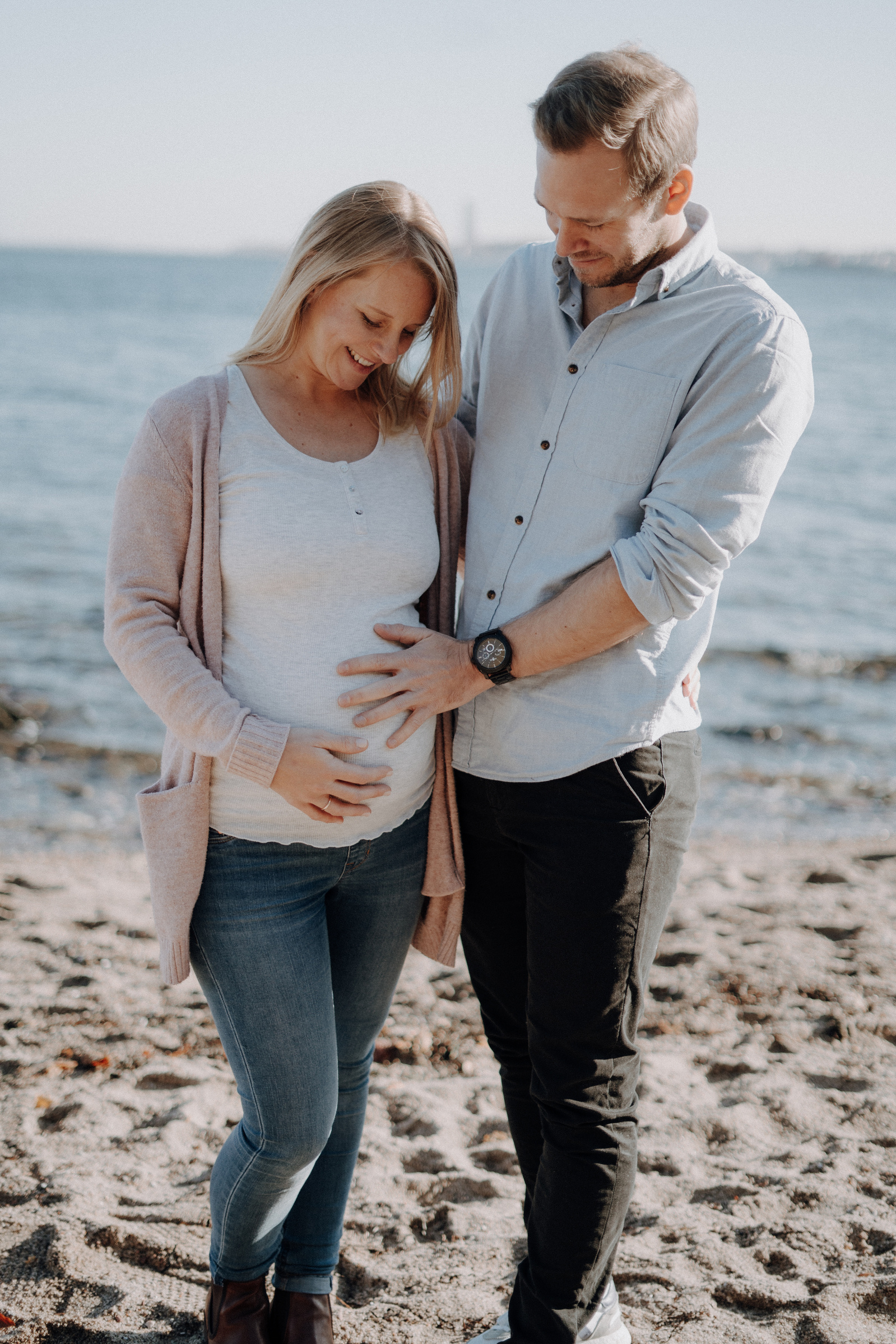 Junges Paar am Strand erwartet ein Baby.
