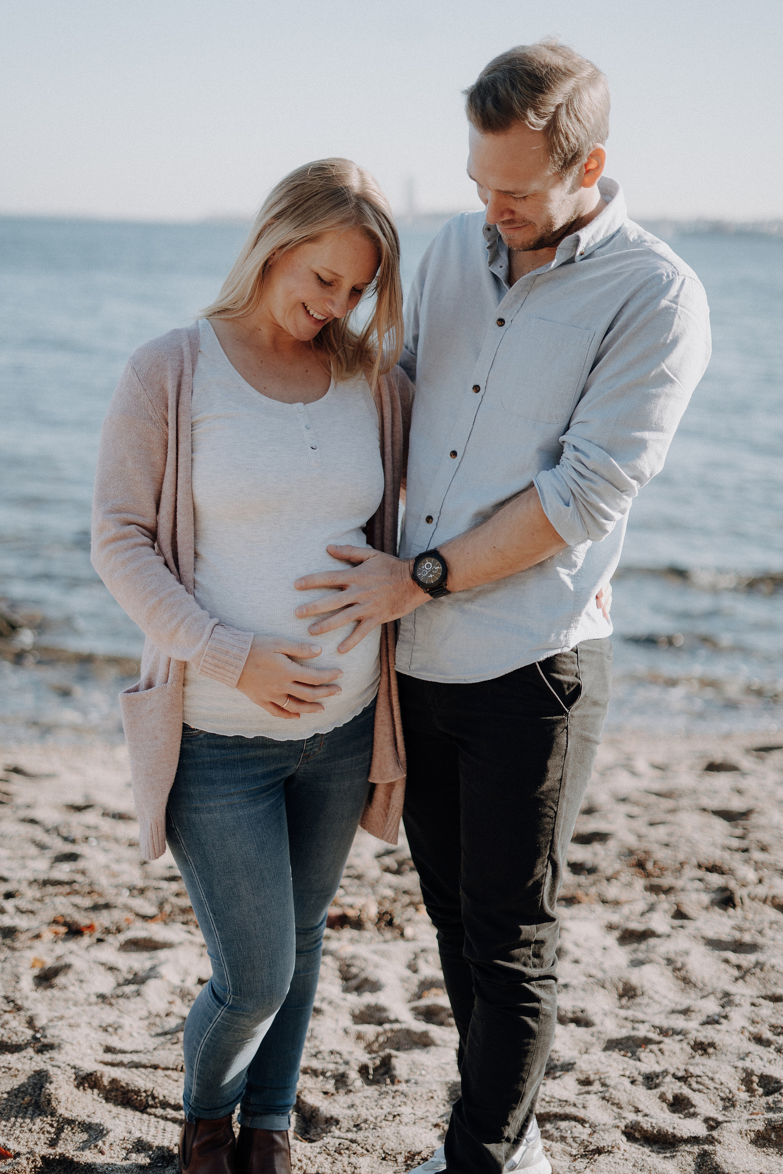 Junges Paar am Strand erwartet ein Baby.
