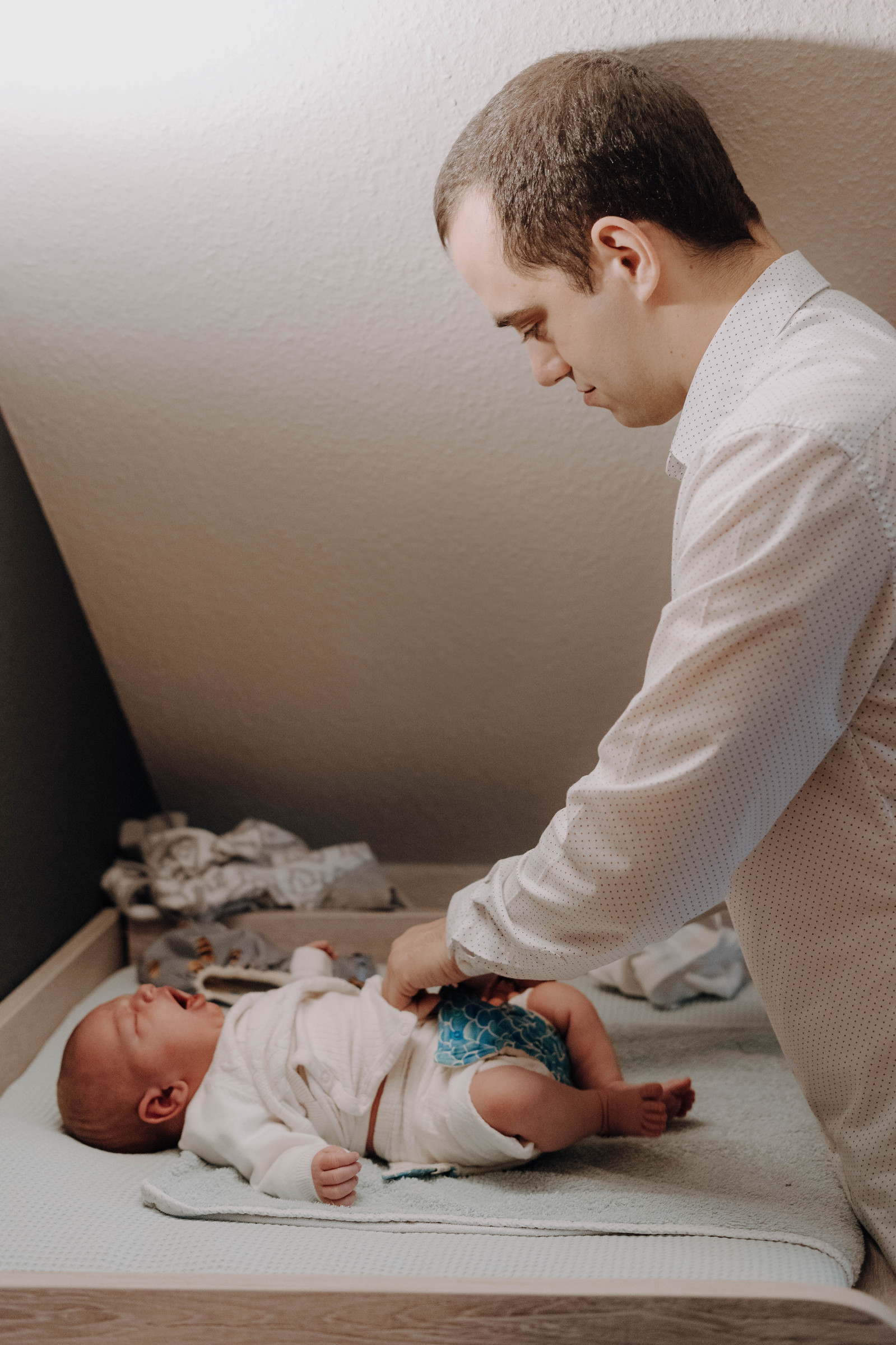 Junger Vater wickelt sein Baby.