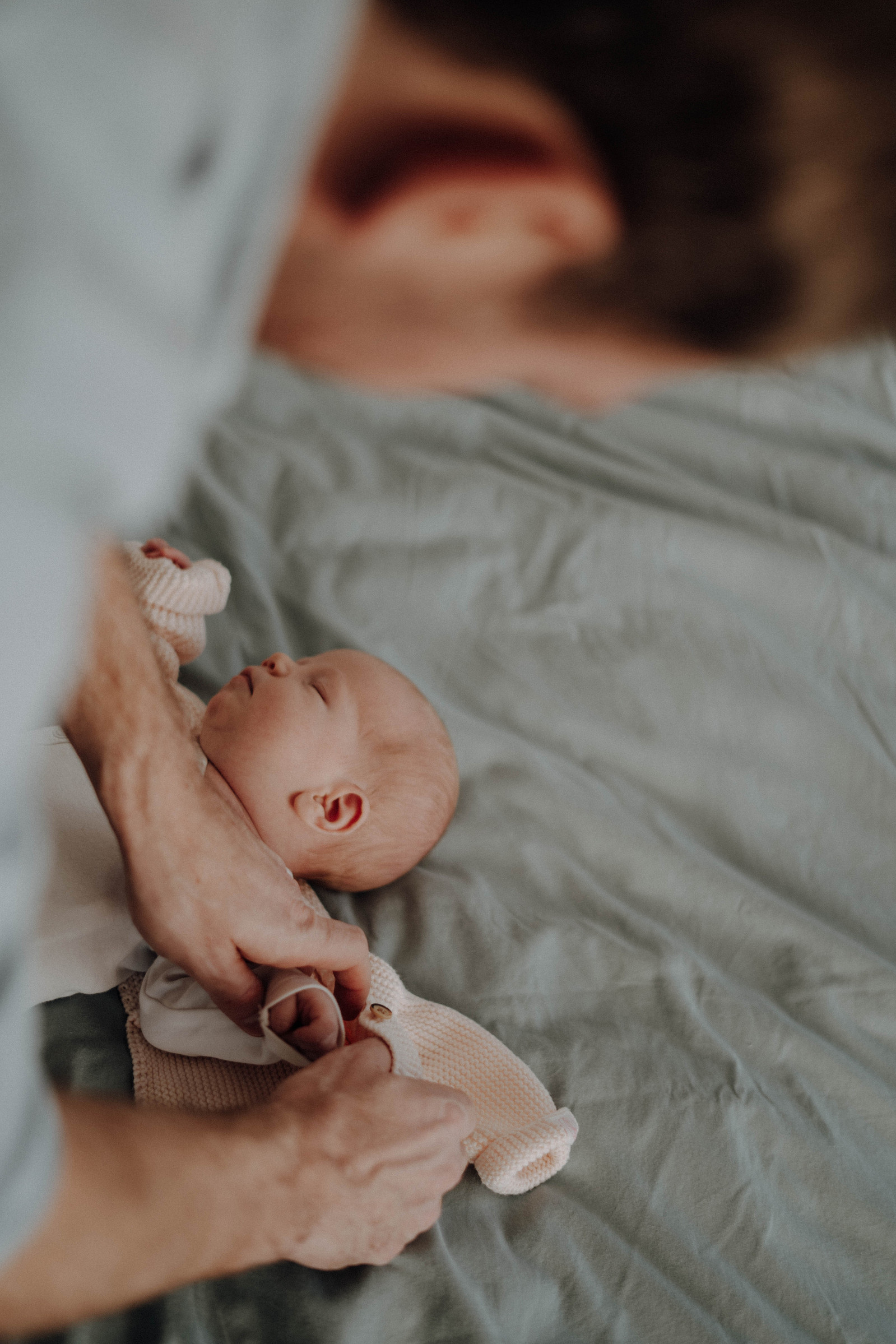 Papa zieht neugeborenes Baby an.