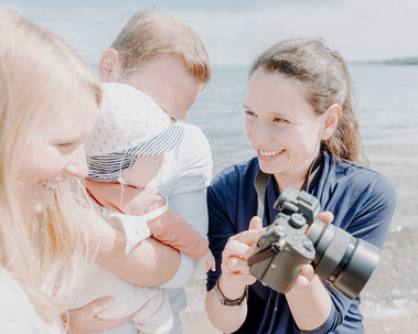 Familienfotografin Katharina Rose aus Kiel fotografiert eine junge Familie mit Baby am Strand.