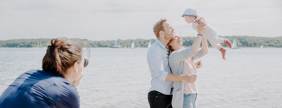 Familienfotografin Katharina Rose aus Kiel fotografiert eine junge Familie mit Baby am Strand.