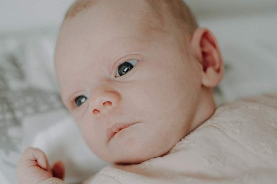 Neugeborenes Baby schaut mit offenen Augen.