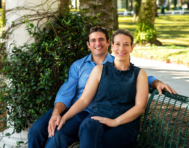 A young couple sits on a bench outdoors