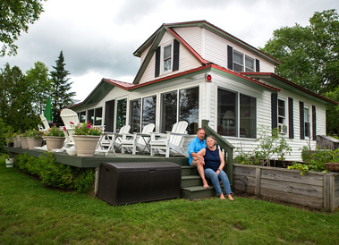 A married couple sit on their porch steps in Vermont