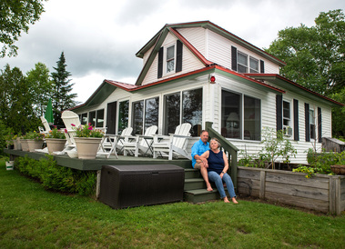 A married couple sit on their porch steps in Vermont