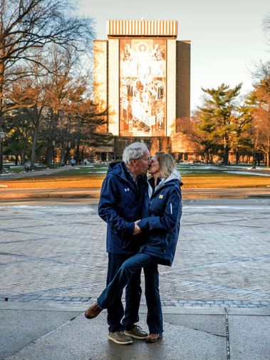 A married couple kiss in front of Touchdown Jesus on the Notre Dame campus in Indiana