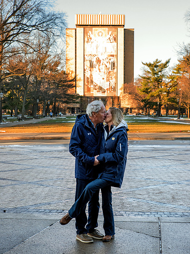 A married couple kiss in front of Touchdown Jesus on the Notre Dame campus in Indiana