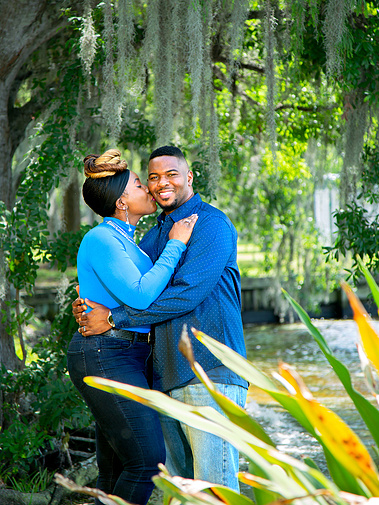 A married couple stand outside under a canopy of trees in Florida