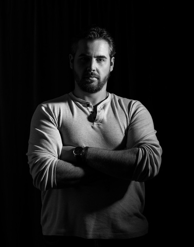 A man poses for a black and white portrait project by Dark Light Portrait Studios of Williamsburg, VA