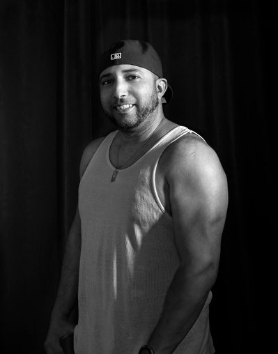 A hispanic man poses for portraits for The Man Project by Dark Light Portrait Studios