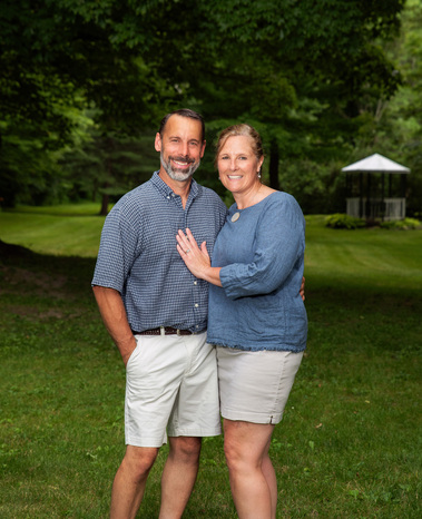 A couple stand together outside in Vermont