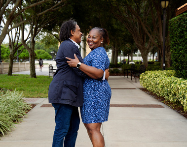 An African American couple dance together outside