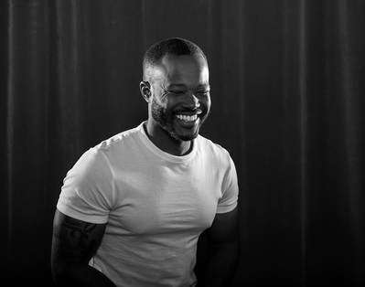 A man laughs in a black and white portrait during his session for The Man Project by Williamsburg, VA photographer Dark Light Portrait Studios