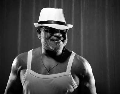 A man poses in a white hat and glasses for a photography project called The Man Project