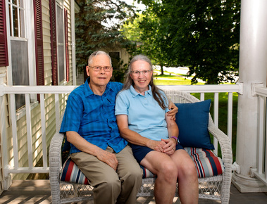 An older couple sit on their porch in Vermont