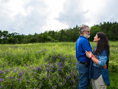 A married couple in a field of flowers in Vermont