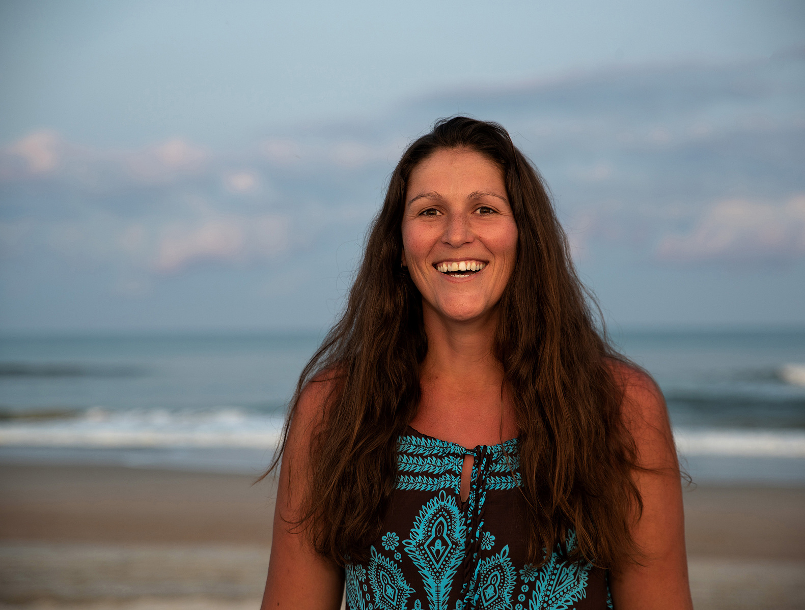 A woman laughs while on the beach in North Carolina