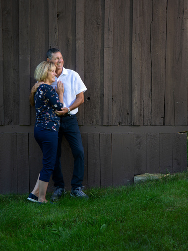A married couple stand by their barn in Vermont