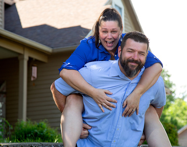 A husband gives his wife a piggy back ride