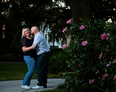 A man kisses his wife in the park