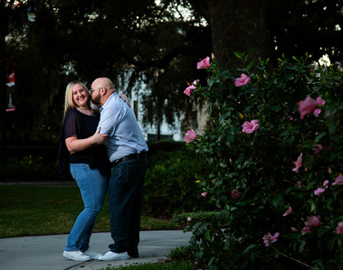 A man kisses his wife in the park