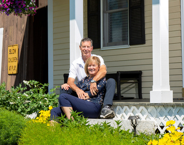 A married couple sit on their porch steps in Vermont