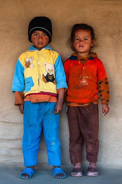 Colorfully clothed young siblings at their home in the Himalayan foothills in Nepal 