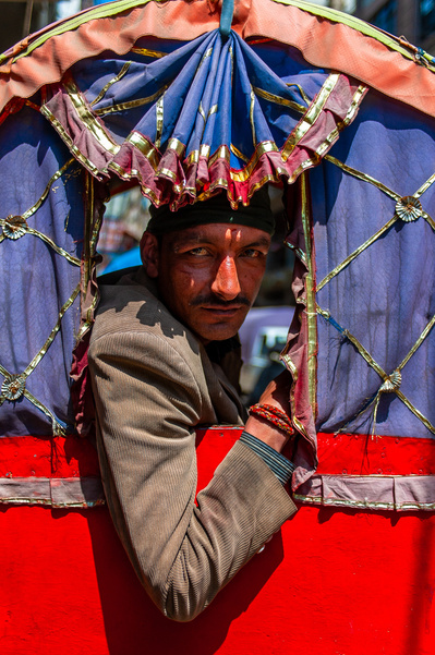 Marketing photography close up of a rickshaw driver in his rickshaws' window in Kathmandu, Nepal