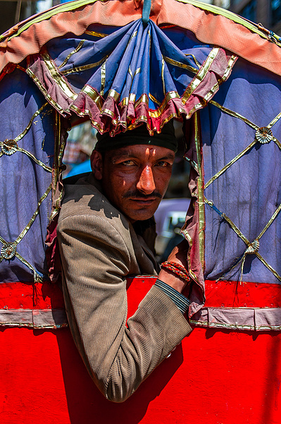 Marketing photography close up of a rickshaw driver in his rickshaws' window in Kathmandu, Nepal