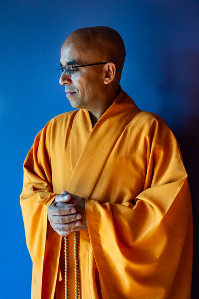 Contemplative and meditative pose of a Buddhist monk in orange robe