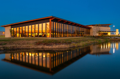 Modern corporate building reflecting in a lake at dusk