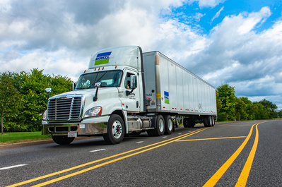 Product photography Chicago depicting a Bunzl semi truck with trailer in transit on a sunny day on a stretch of highway