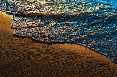 Wave arriving at a beach at dusk at Lake Michigan
