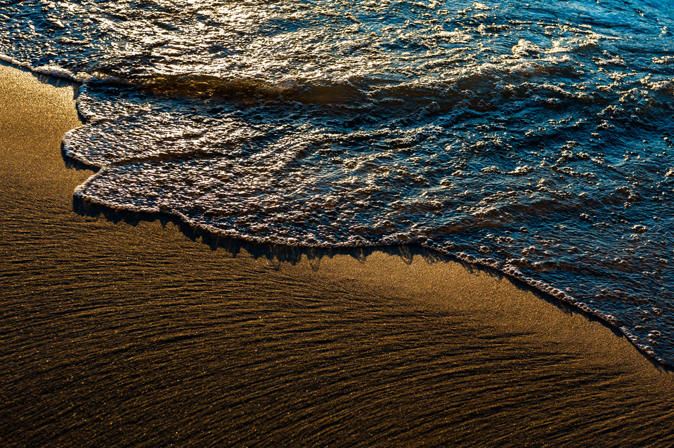 Glistening wave splashing onto the beach at Lake Michigan 