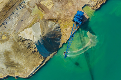 Aerial photographer take on gravel excavation from a lake by a crane