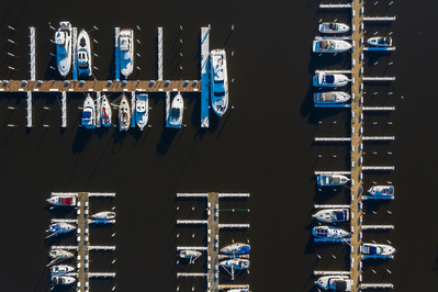 Aerial view of yachts and sail boats in late afternoon sunlight during early spring at a yacht harbor in Michigan City, IN